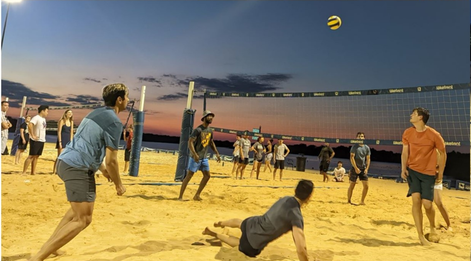 Students playing volleyball on a beach